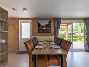a dining room with a wooden table and chairs at Woodchalet in Vessem