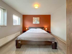 a bedroom with a large bed with orange walls at Alpacafarm Vorstenbosch in Vorstenbosch