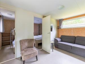 a living room with a couch and a chair at Woodchalet in Vessem