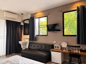 a bedroom with a bed and a desk and a television at i-river chiangmai in Chiang Mai