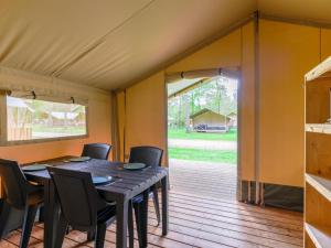 a dining room with a table and chairs in a tent at Safaritent 4 in Vessem