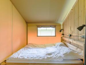 a bed in a small room with a window at Safaritent 4 in Vessem +16 photos