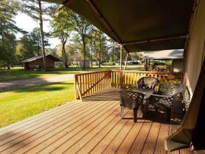a wooden deck with a table and chairs on it at Safaritent 4 in Vessem