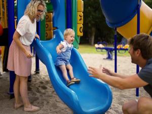 a woman and a child on a slide at a playground at Safaritent 4 in Vessem