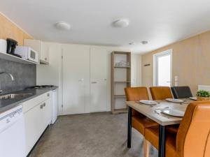 a kitchen with a table and chairs in a kitchen at Woodlodge XL 588 in Vessem