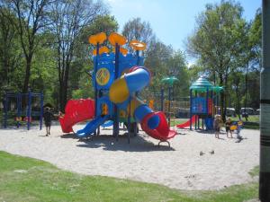 a playground in a park with children playing on it at Safaritent 6 in Vessem