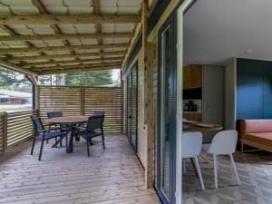 a patio with a table and chairs and a couch at Boslodge in Vessem