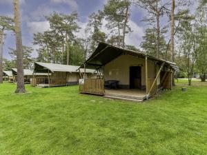 a large green tent with a picnic table in a field at Safaritent 6 in Vessem