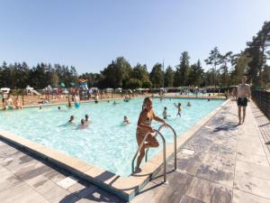 a young girl climbing a hand rail in a swimming pool at Safaritent 7 in Vessem