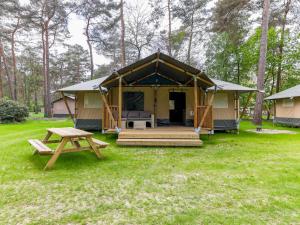 a yellow tent with a picnic table in a yard at Safaritent 7 in Vessem