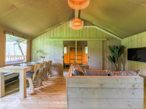 a dining room with a table and a table and chairs at Safaritent 7 in Vessem