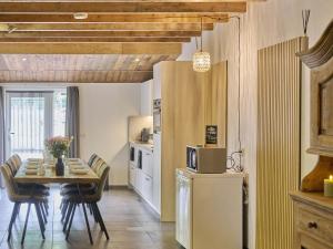 a kitchen and dining room with a table and a refrigerator at De Rouwenbogt in Reusel