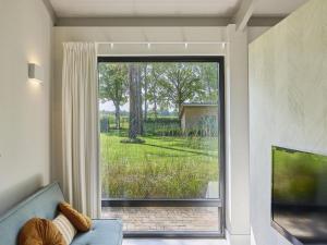 a living room with a large window and a couch at Quercus in Valkenswaard