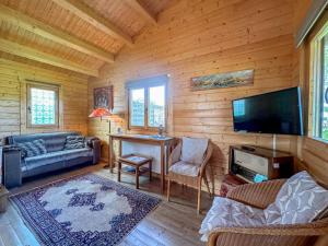 a living room with wooden walls and a flat screen tv at Onder de oude Eik in Lottum
