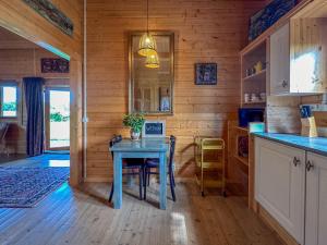 a dining room with a blue table in a cabin at Onder de oude Eik in Lottum