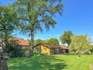 a house with a large tree in the yard at Onder de oude Eik in Lottum
