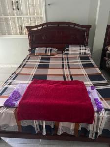a bed with a red blanket on top of it at Nhà nghỉ Bình Long in Thiện Chánh (1)