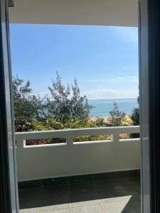 a sliding glass door with a view of the ocean at Nhà nghỉ Bình Long in Thiện Chánh (1)