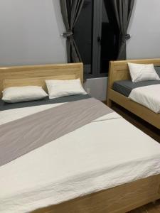 two beds sitting next to each other in a room at Du mục stay in Ninh Hải