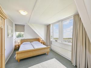 a bedroom with a bed and a large window at Rose Garden in Stevensweert