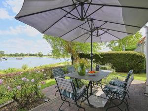 a table and chairs with an umbrella on a patio at Rose Garden in Stevensweert