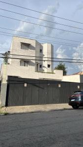 a building with a fence and a car parked in front of it at Hotel e Pousada Porto Forte in São Paulo
