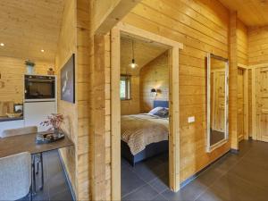 a bedroom in a log cabin with a bed at Bie Leentje op de wei in Schinnen