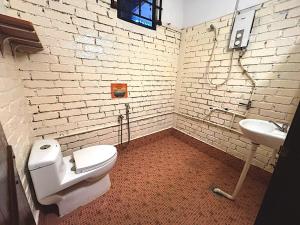 a bathroom with a white toilet and a sink at Home Sol Guesthouse in Pantai Cenang +41 photos