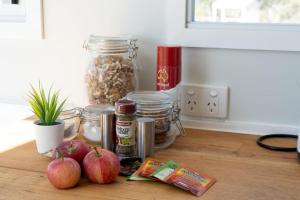 a counter with apples and jars of nuts on a table at Saddle Camp Tiny House by Tiny Away in Braidwood +13 photos