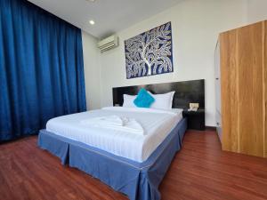 a bedroom with a large white bed with blue pillows at Jason Residencia One Hotel in Phnom Penh