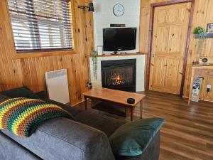 a living room with a couch and a fireplace at Refuge Boréal - Bord du lac paisible in Saint-Ambroise