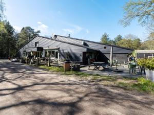 a black barn with a porch and a patio at Mos in Nunspeet