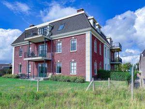 a large red brick building with a balcony at SeaLuxe Residence 27C in Colijnsplaat