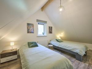 a attic bedroom with two beds and a window at De Linde in Nunspeet