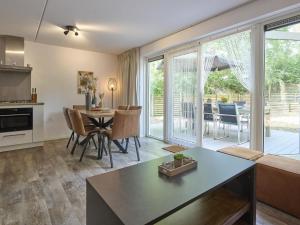 a kitchen and living room with a table and chairs at De Linde in Nunspeet