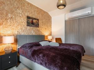 a bedroom with a large bed with a purple blanket at De Fazant in Hulshorst +50 photos