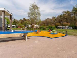 a park with a playground with a table and swings at De Fazant in Hulshorst