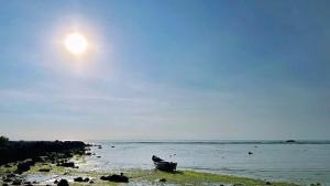 a boat sitting on the shore of a beach at Du mục stay in Ninh Hải