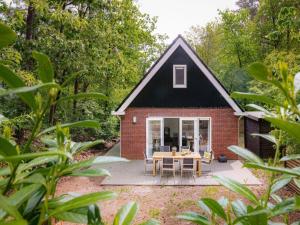 a small red brick house with a table and chairs at De Linde in Nunspeet