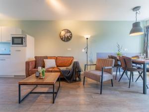 a living room with a couch and a table at Kuifmees in Hulshorst
