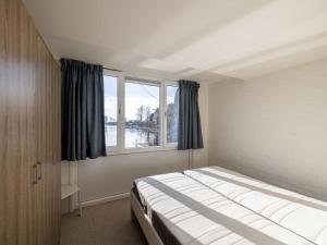 a bedroom with a bed and a window at Kieft in Boornzwaag