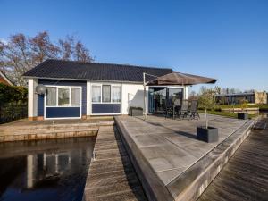 a house with a wooden deck next to a body of water at Kieft in Boornzwaag