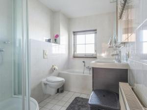 a white bathroom with a toilet and a sink at Schippershuis Stavoren in Stavoren +18 photos