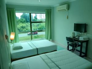 a hotel room with two beds and a window at Highway Inn in Mukah