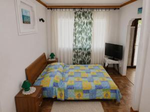 a bedroom with a bed and a television at Ina in Funtana