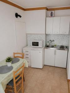 a small kitchen with a table and a microwave at Ina in Funtana
