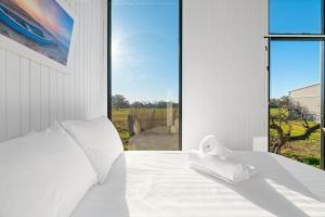a bedroom with a white bed with a large window at Starry Night Farmstay by Tiny Away in Forbes