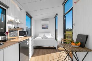 a bedroom with a bed and a kitchen with a table at Starry Night Farmstay by Tiny Away in Forbes