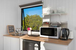 a kitchen counter with a microwave and a window at Starry Night Farmstay by Tiny Away in Forbes +33 photos