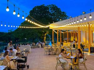 people sitting at tables on a patio at night at Asia Pattaya Hotel in Pattaya South